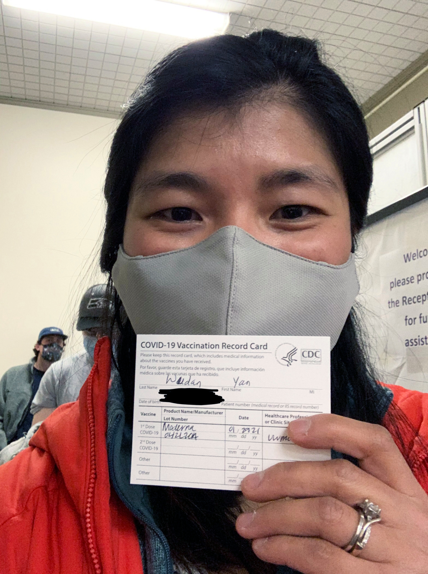 Photograph of Wudan Yan holding her vaccination record card