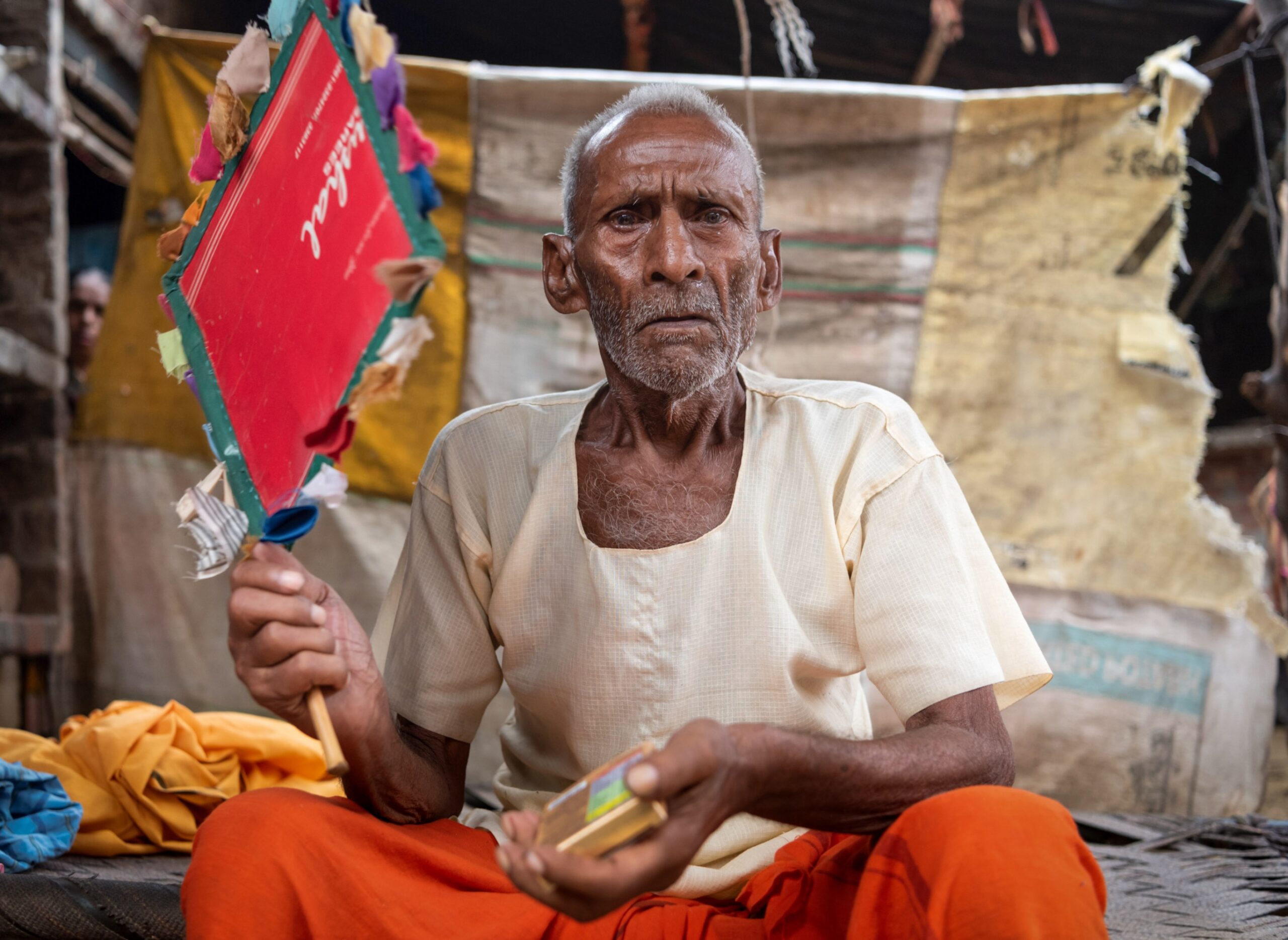 Raja Ram, 97, fans himself with a handmade fan