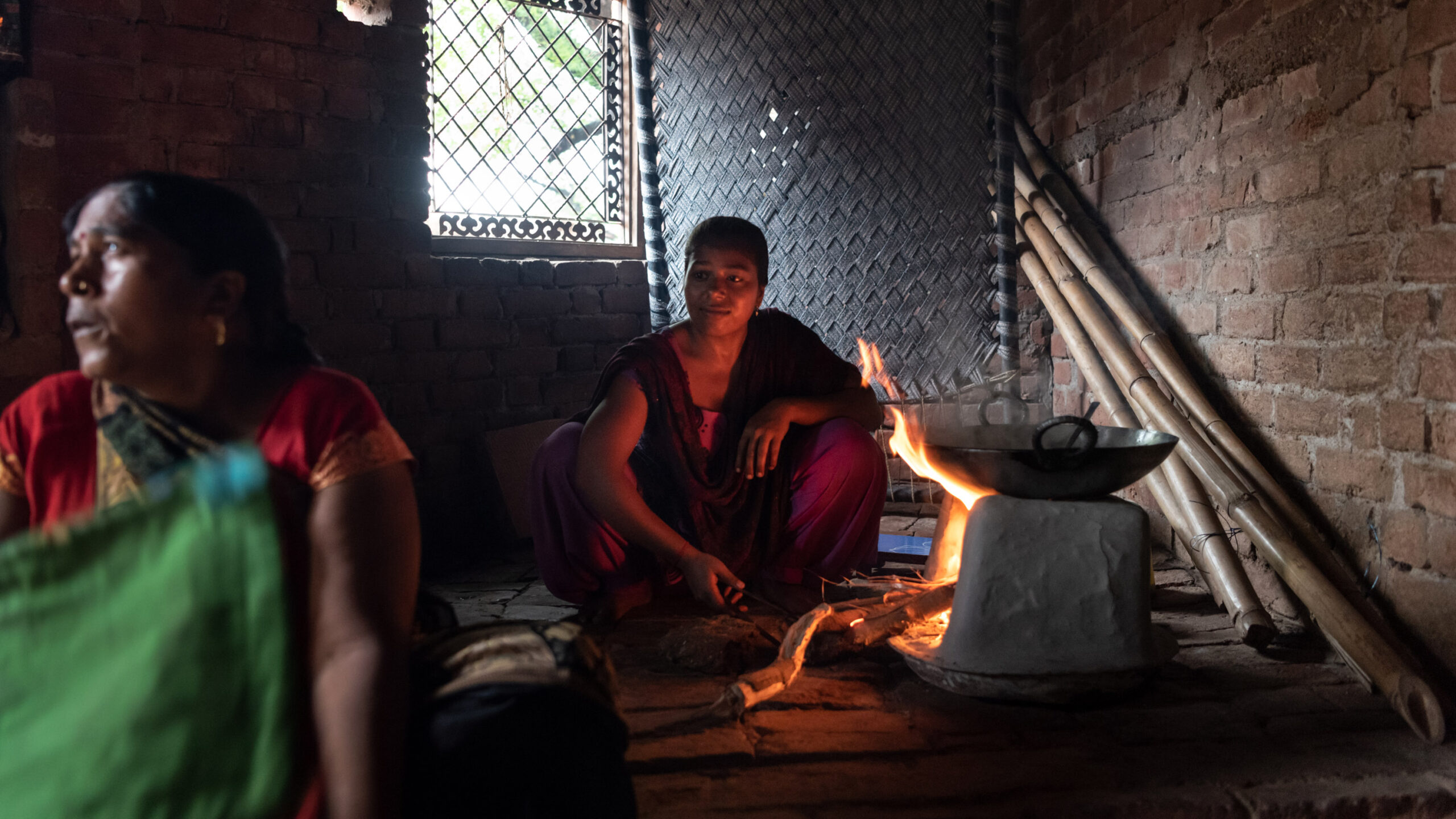Divya, 20, prepares a meal at her home amid the searing heat