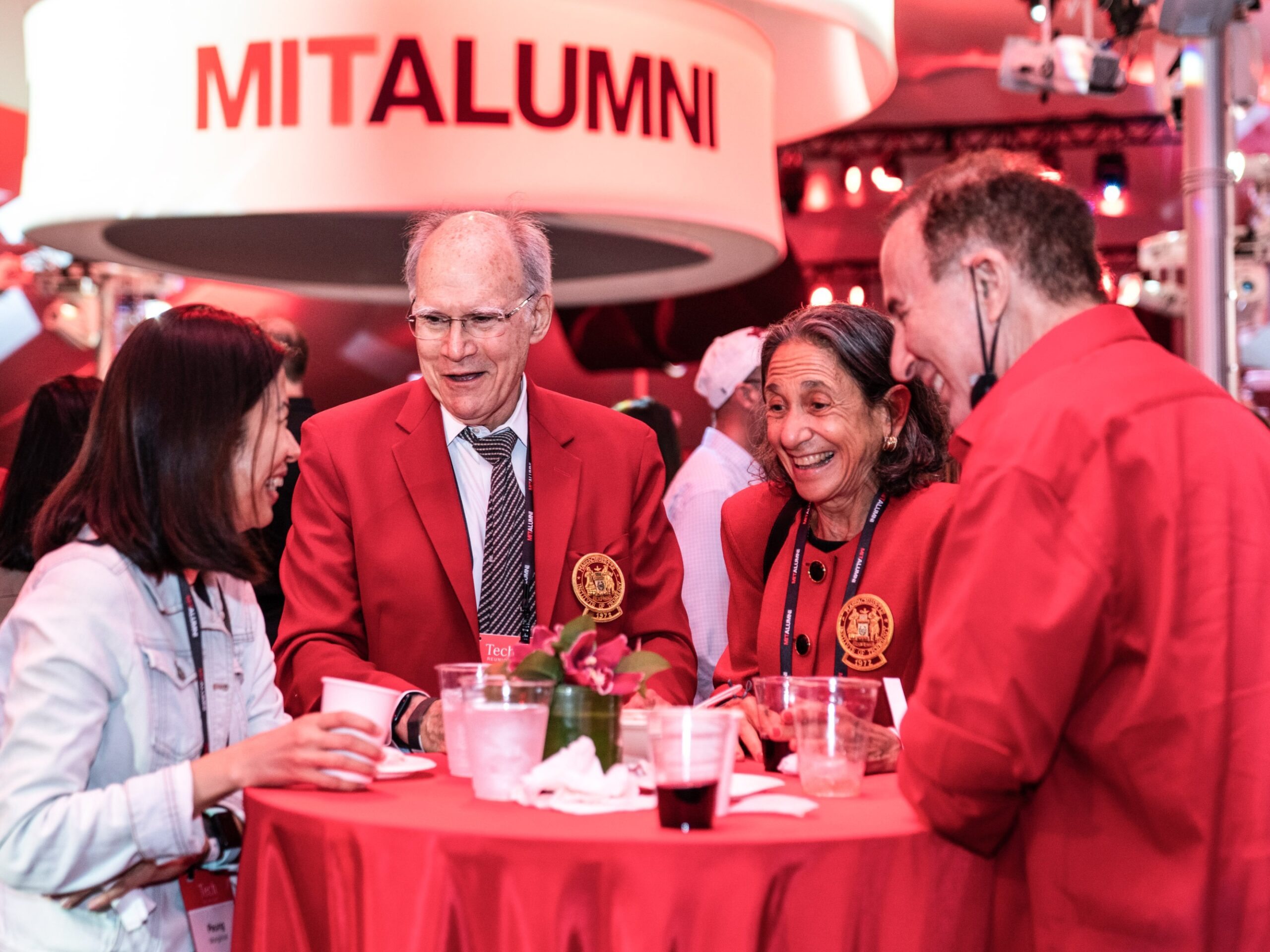 guests around a table under a banner reading MIT Alumni