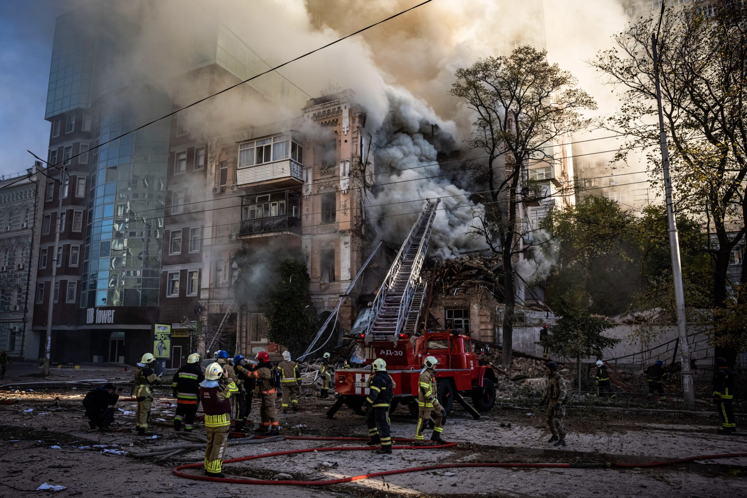 Emergency responders work to clear debris from a Russian Shahed-136 strike on a building in Kyiv as smoke pours out into the sky
