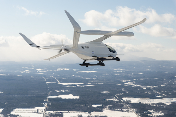 a small white plane with a propellor on the back flies over a landscape