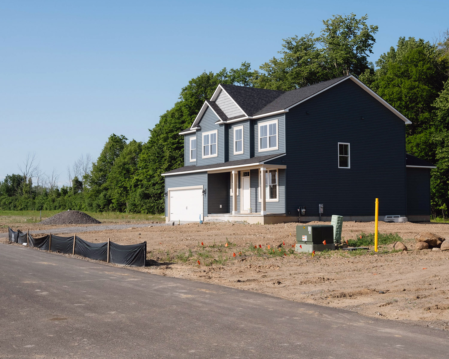 A completed new home is shown in an empty new housing development