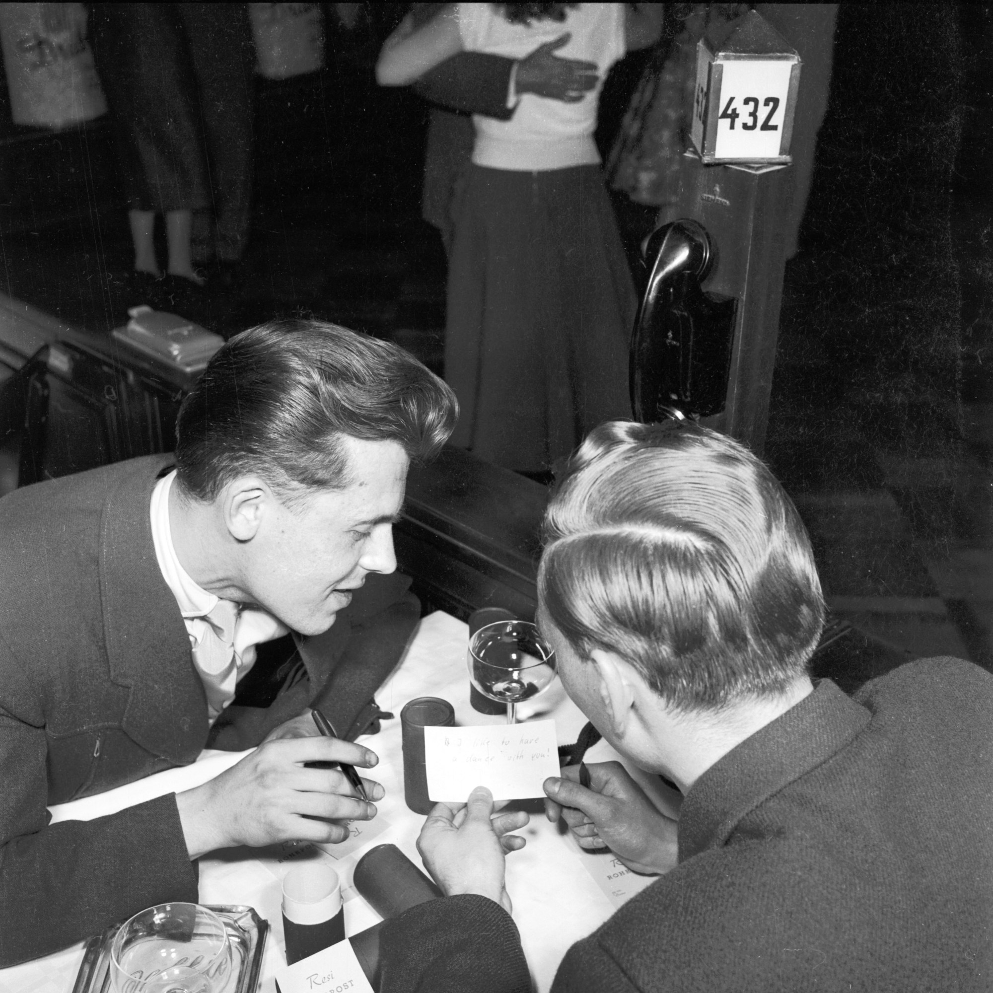 two people reading a note at a table