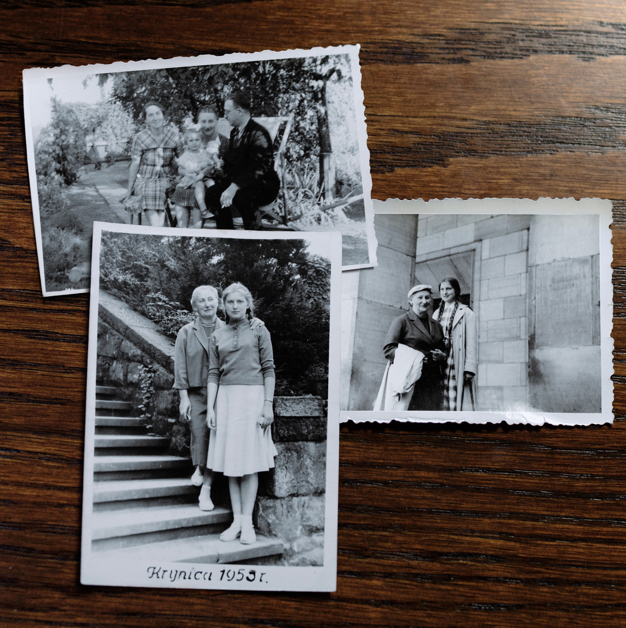three black and white photos on a wood table