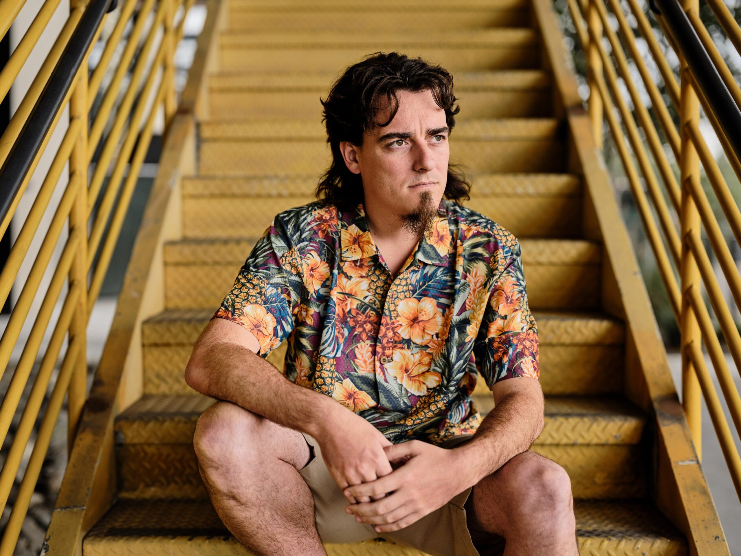 Palmer Luckey sitting on yellow metal staircase