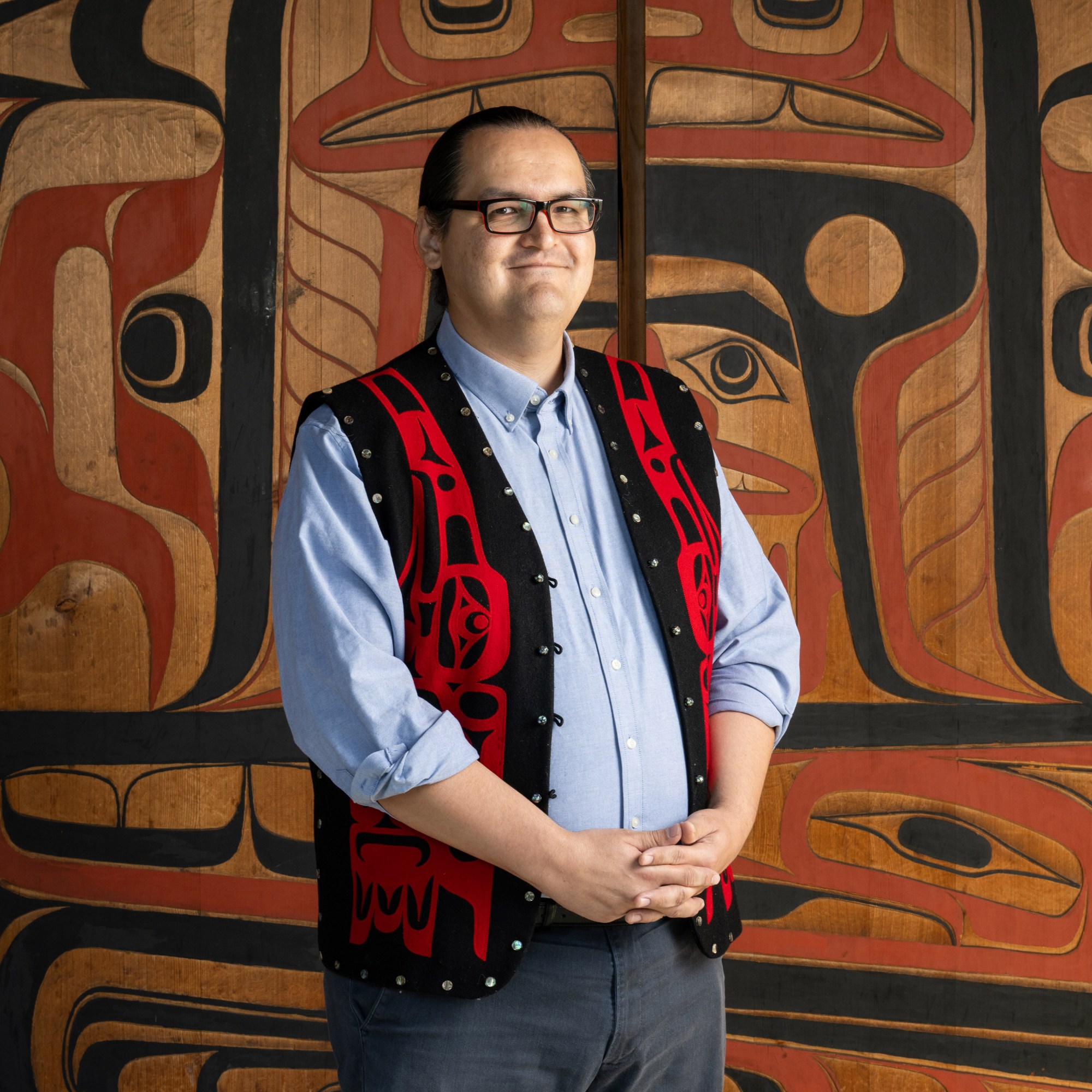 Anthony Jones standing in front of a decorated wood wall